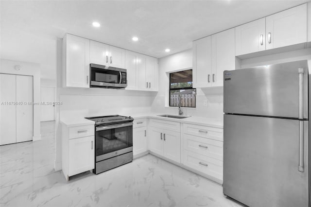 kitchen featuring sink, appliances with stainless steel finishes, and white cabinets