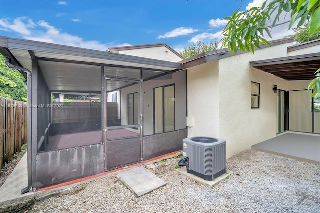 view of patio with a sunroom and central AC