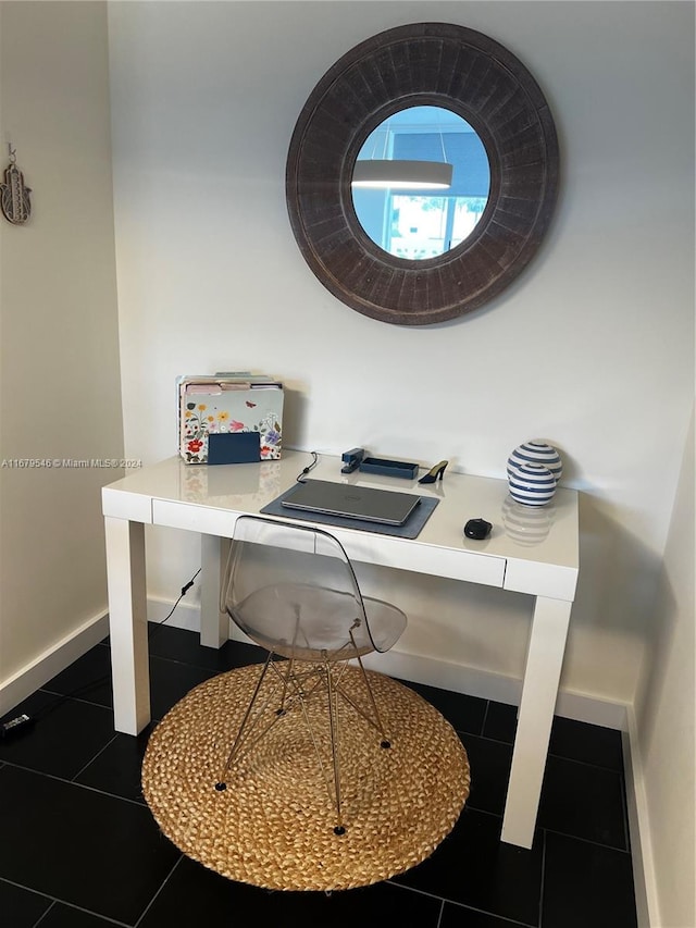 office space with built in desk and dark tile patterned floors