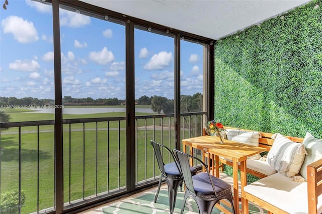 sunroom / solarium featuring a water view