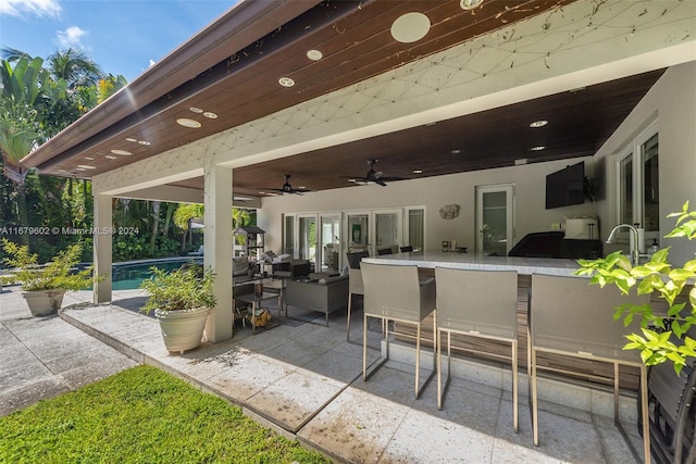 view of patio / terrace featuring exterior bar and ceiling fan