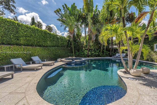 view of swimming pool featuring a patio area and an in ground hot tub