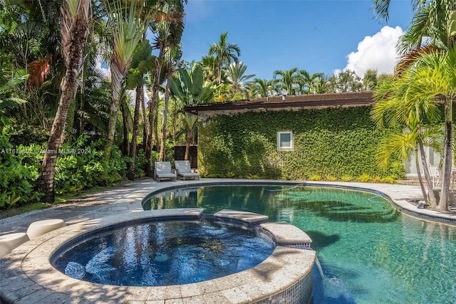 view of swimming pool featuring an in ground hot tub and a patio area