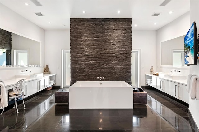 bathroom featuring a bathing tub, a high ceiling, vanity, and plenty of natural light