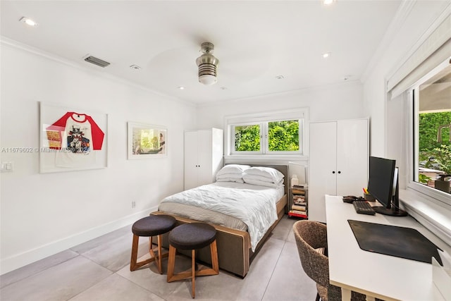 tiled bedroom with ornamental molding and ceiling fan