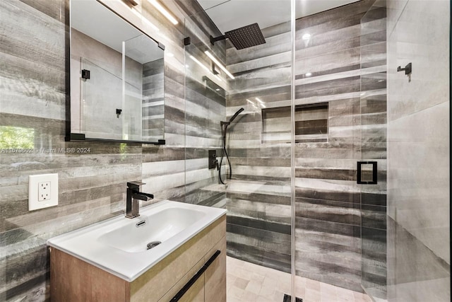 bathroom with vanity, tasteful backsplash, tile walls, and a shower with shower door