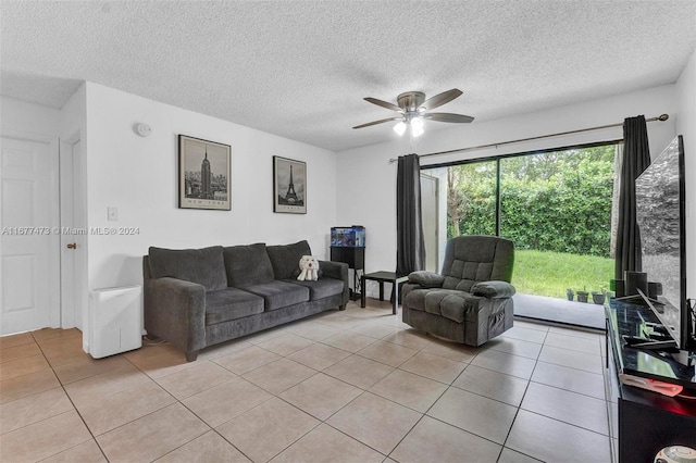 living room featuring ceiling fan, a textured ceiling, and light tile patterned floors