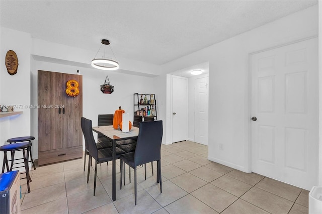 tiled dining room with a textured ceiling