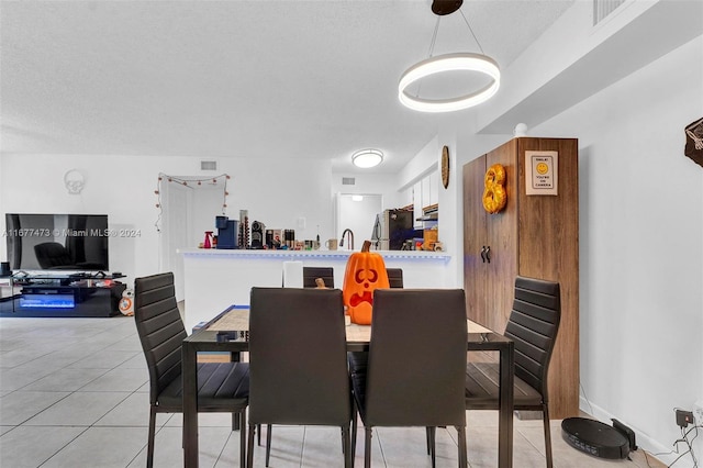 dining space with a textured ceiling and light tile patterned floors