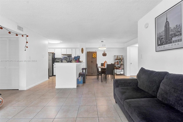 living room featuring a textured ceiling and light tile patterned floors