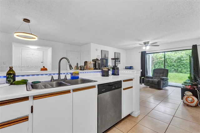 kitchen featuring decorative light fixtures, white cabinets, stainless steel dishwasher, and a textured ceiling