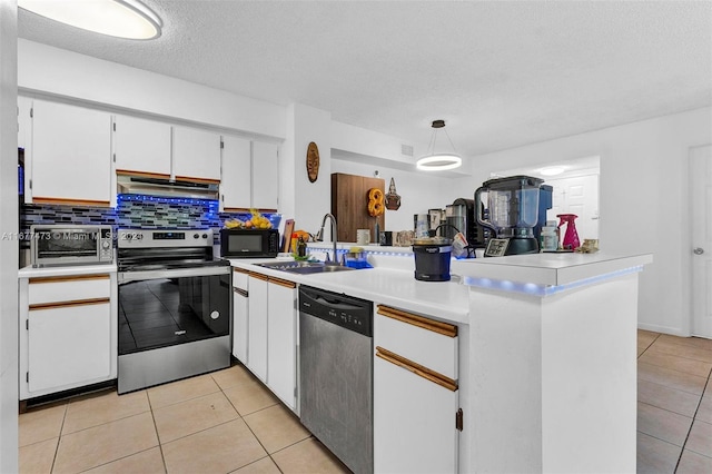 kitchen with sink, hanging light fixtures, white cabinetry, stainless steel appliances, and range hood