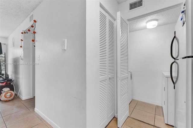 interior space featuring a textured ceiling and light tile patterned flooring