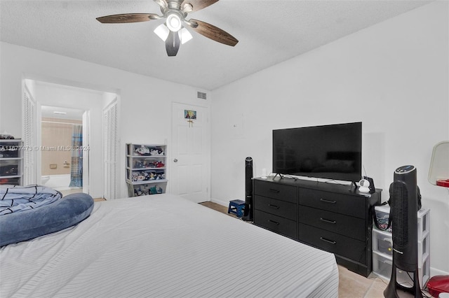 tiled bedroom featuring a textured ceiling and ceiling fan