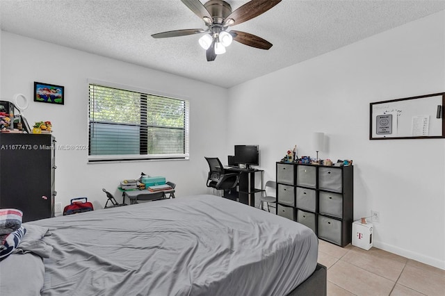 tiled bedroom featuring ceiling fan and a textured ceiling