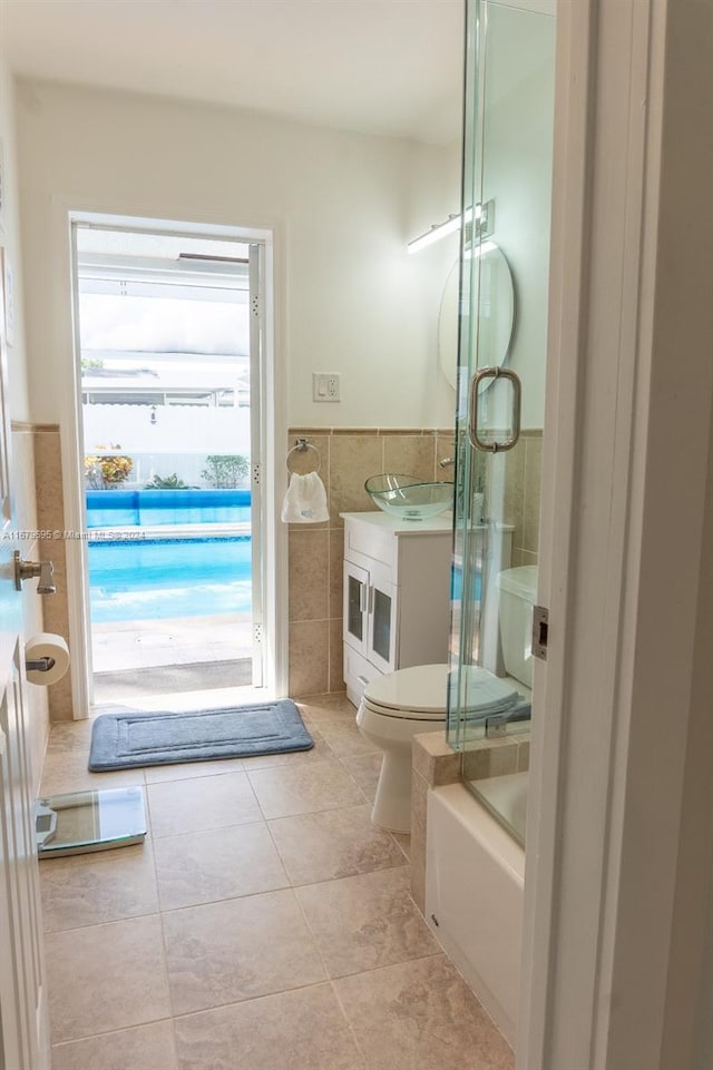 full bathroom featuring shower with separate bathtub, tile walls, toilet, vanity, and tile patterned flooring