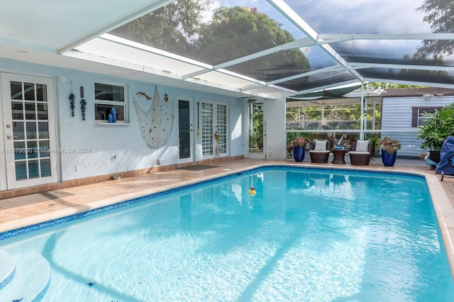 view of swimming pool with a patio, french doors, and glass enclosure