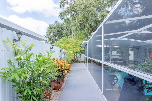 exterior space with a fenced in pool and glass enclosure