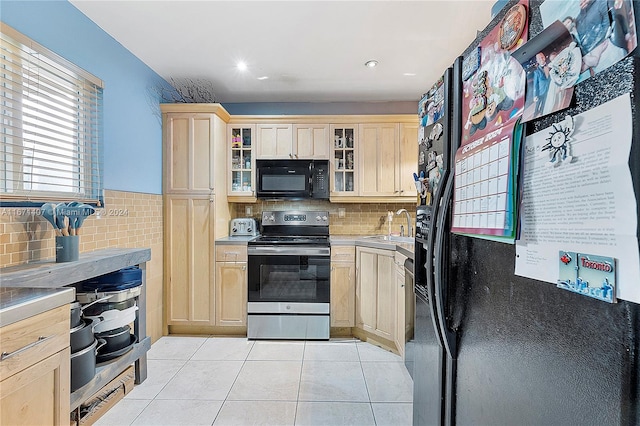 kitchen with light brown cabinets, backsplash, sink, black appliances, and light tile patterned floors