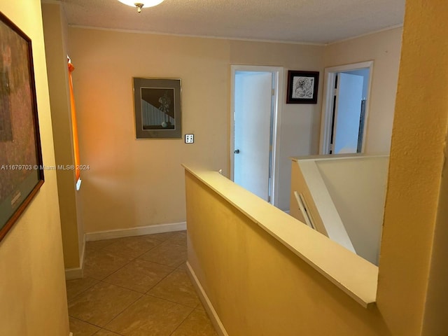 hallway featuring a textured ceiling and tile patterned flooring