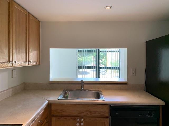 kitchen featuring black appliances, a sink, light countertops, and recessed lighting