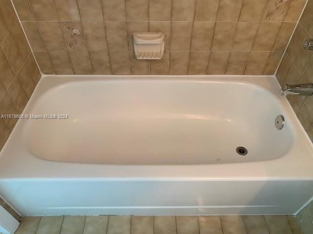 bathroom with a tub and tile patterned floors