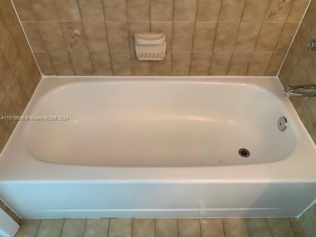 full bathroom with a tub to relax in and tile patterned flooring