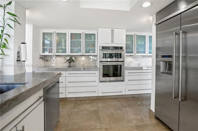 kitchen featuring white cabinets, stainless steel appliances, and tasteful backsplash