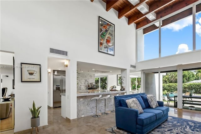 living room featuring high vaulted ceiling, wooden ceiling, sink, and beamed ceiling