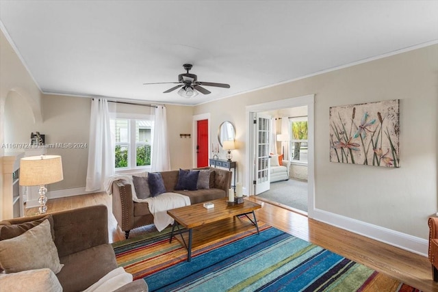 living room featuring ornamental molding, light hardwood / wood-style flooring, and ceiling fan