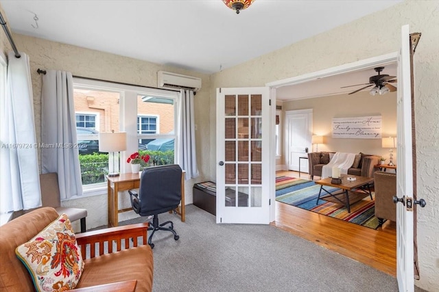 office area featuring a textured wall, carpet flooring, french doors, and a wall mounted air conditioner