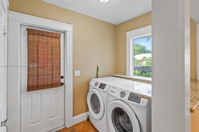 clothes washing area with washer and dryer and a textured ceiling