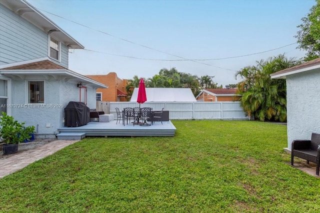 view of yard with outdoor dining space, fence, and a deck