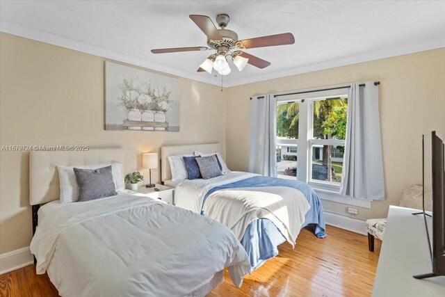 bedroom with ceiling fan, crown molding, and wood-type flooring