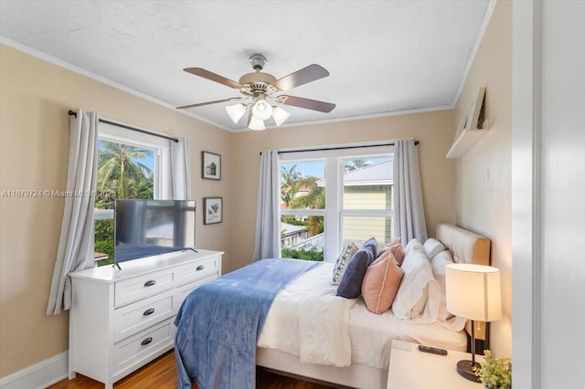 bedroom featuring ceiling fan, ornamental molding, multiple windows, and baseboards