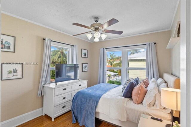 bedroom featuring ornamental molding, hardwood / wood-style flooring, and ceiling fan