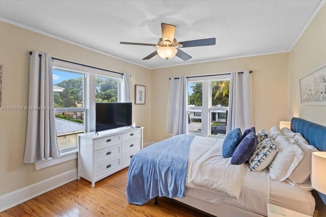 bedroom with light hardwood / wood-style flooring, multiple windows, crown molding, and ceiling fan