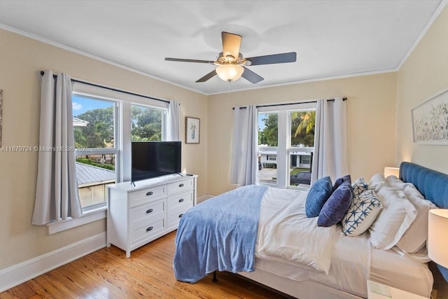 bedroom with light wood-style flooring, multiple windows, and crown molding