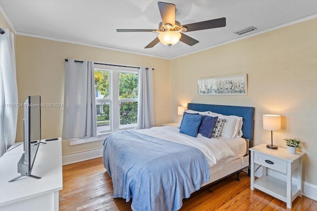 bedroom featuring ceiling fan, hardwood / wood-style flooring, and ornamental molding