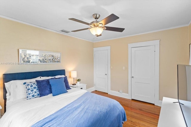 bedroom with ceiling fan, crown molding, and wood-type flooring