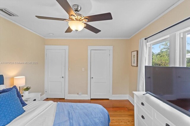 bedroom with ornamental molding, light hardwood / wood-style floors, and ceiling fan