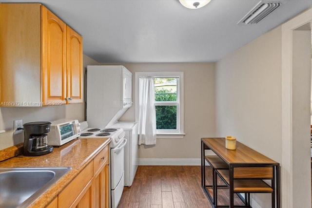 kitchen featuring light brown cabinetry, dark wood-style flooring, visible vents, and white electric range oven