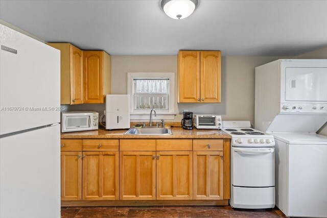 kitchen featuring white appliances, sink, stacked washer and clothes dryer, and dark hardwood / wood-style floors