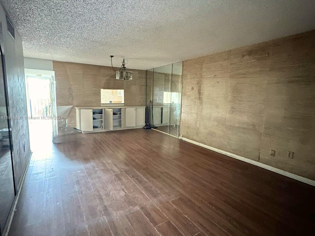 unfurnished living room featuring hardwood / wood-style flooring and a textured ceiling