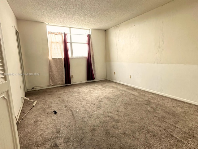 carpeted empty room featuring lofted ceiling and a textured ceiling