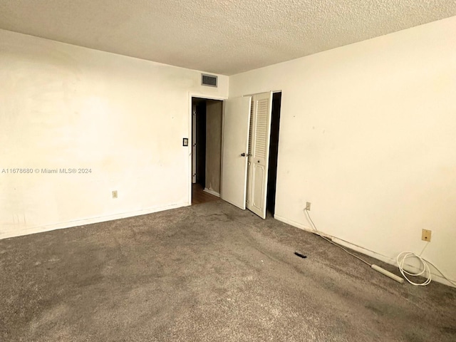 carpeted spare room featuring a textured ceiling