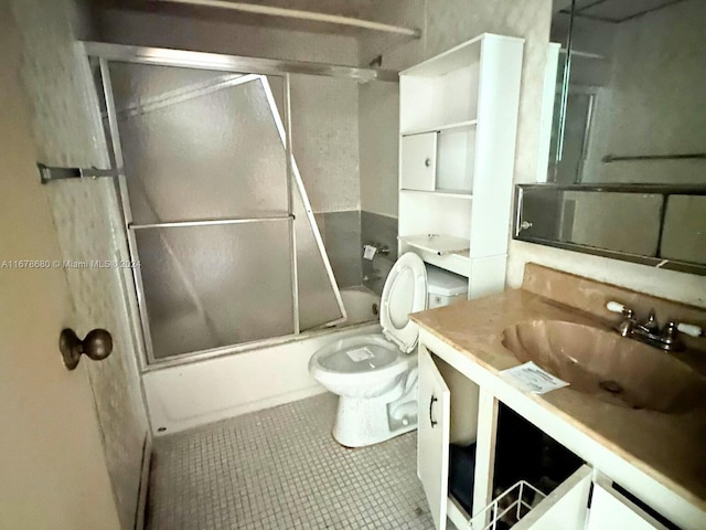 full bathroom featuring vanity, toilet, tile patterned flooring, and bath / shower combo with glass door