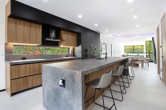 420 SW 15th Rd, Miami, FL 33129 - kitchen with wall chimney exhaust hood, modern cabinets, a breakfast bar, tasteful backsplash, and recessed lighting