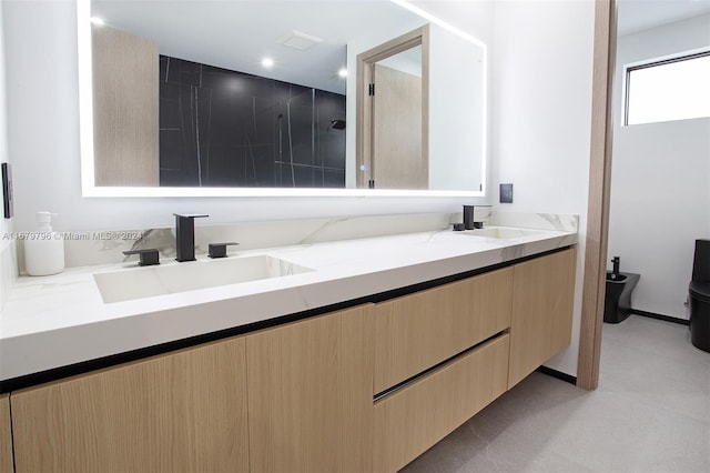 bathroom with vanity, toilet, and a tile shower