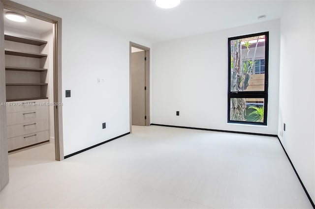 unfurnished bedroom featuring a walk in closet